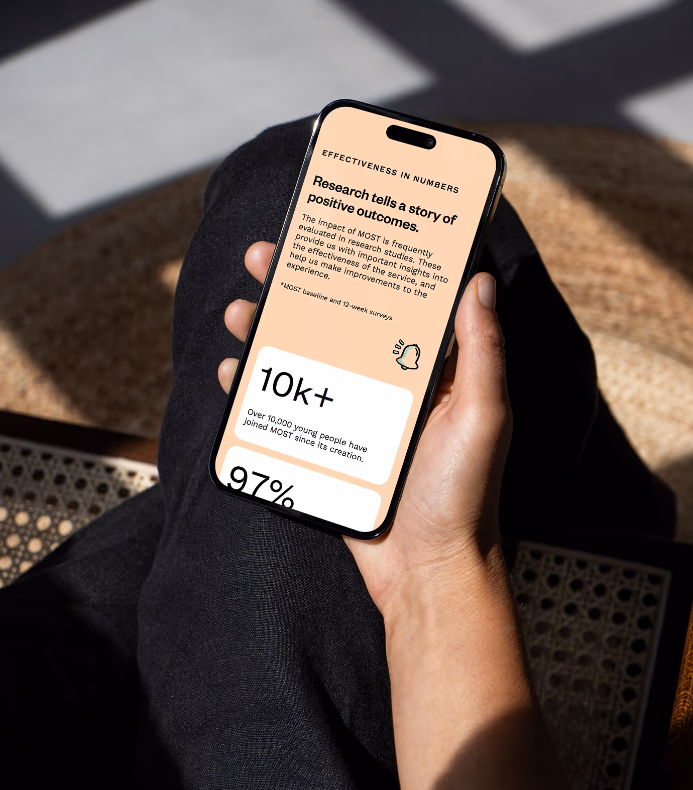 Person sitting down looking at the MOST website on their mobile