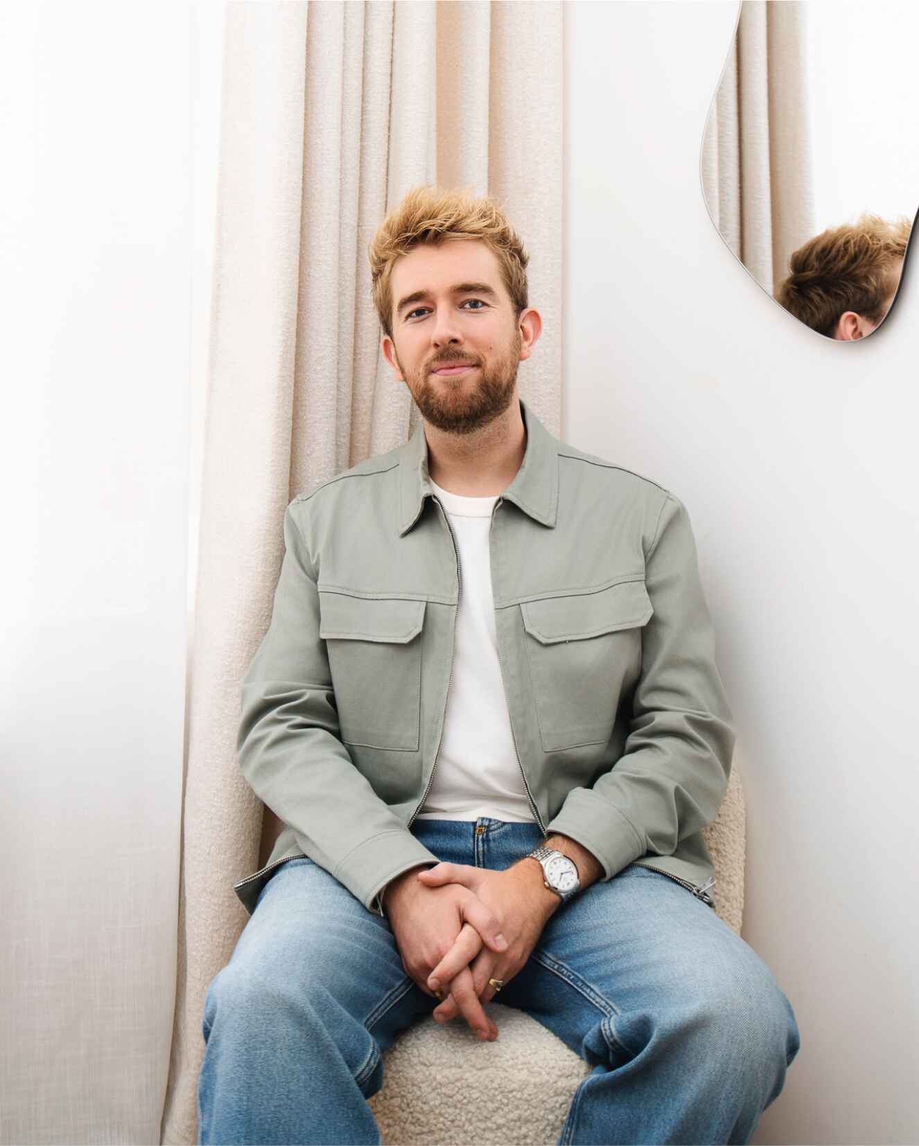 Portrait de Dorian Colin, designer UX/UI & brand basé à Paris, assis dans un intérieur épuré et lumineux.