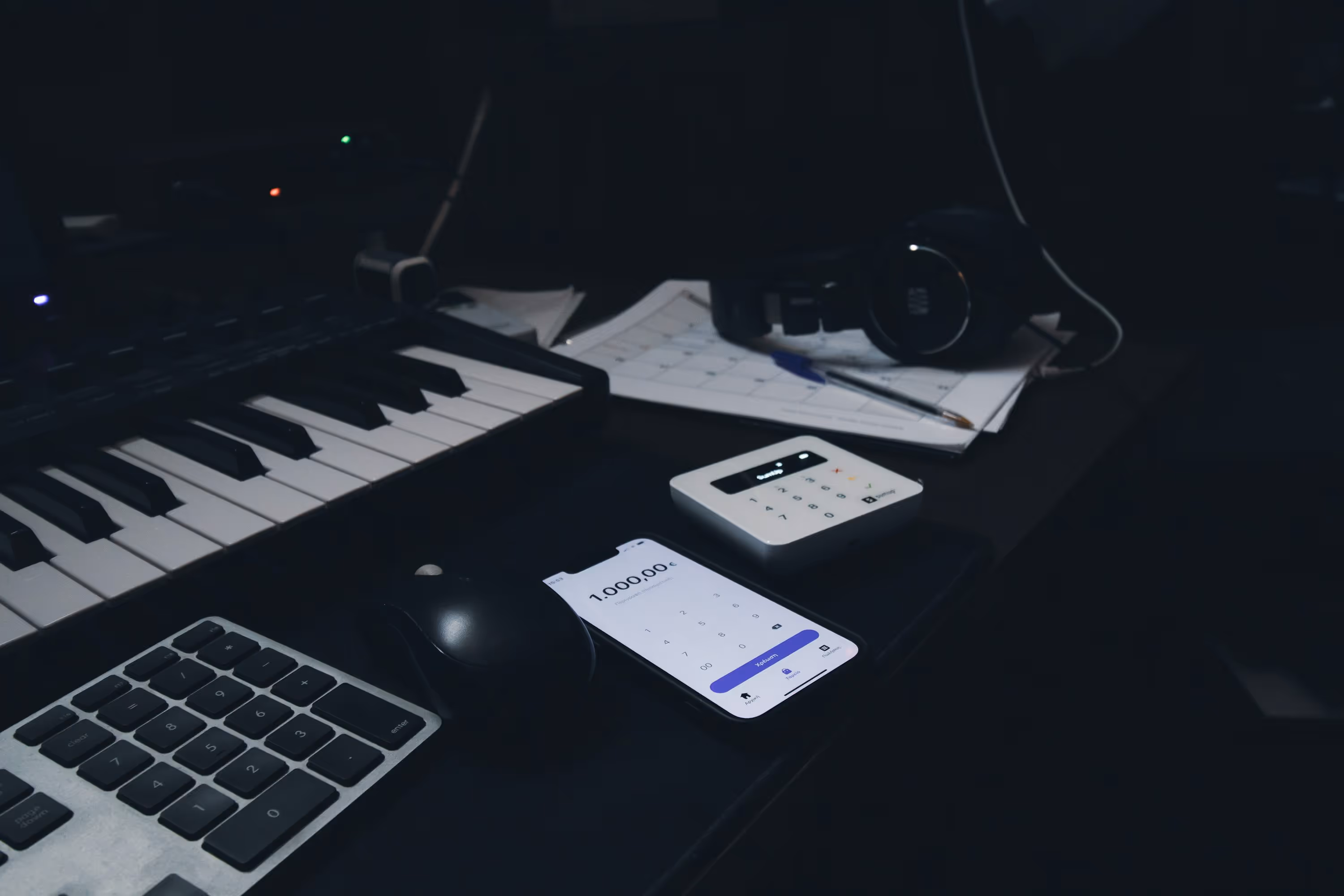 a keyboard, mouse, and cell phone sitting on a desk