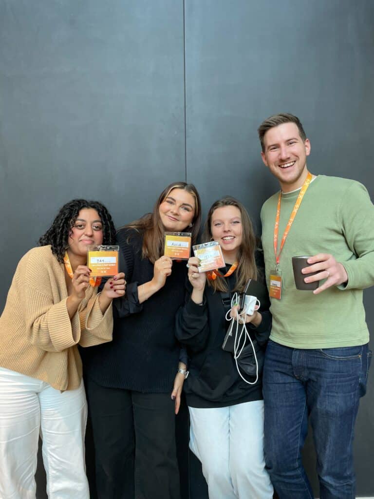 Plus X Brighton team members wearing lanyards with pronouns