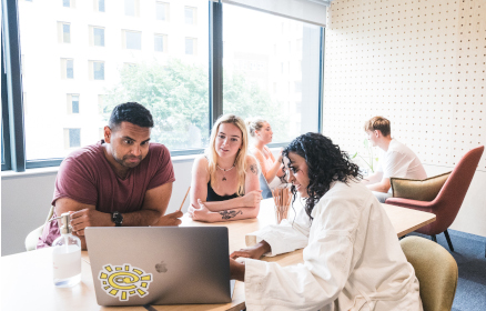 A group of people collaborating at a computer in a Brighton meeting room