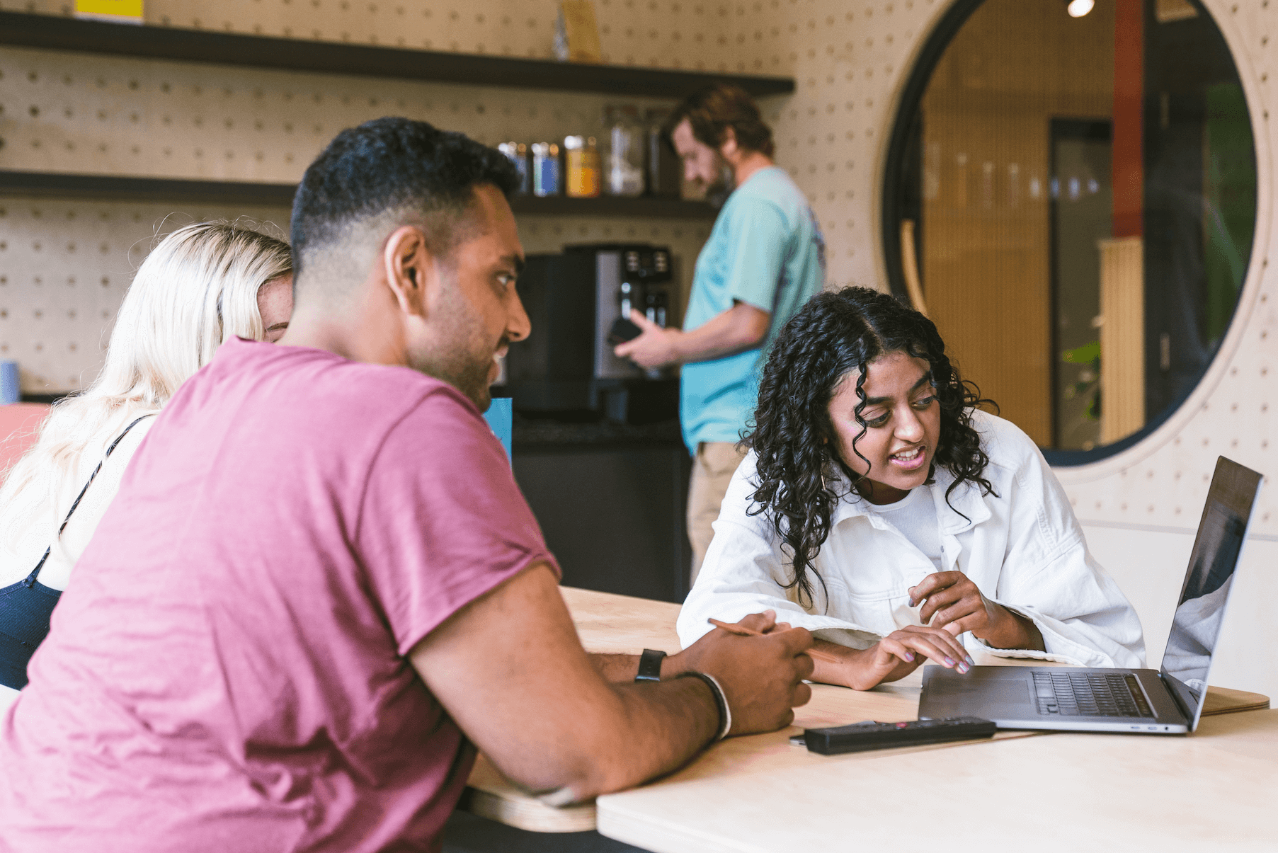 Three people have a meeting at Plus X Innovation