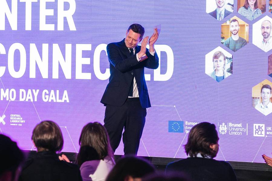 Toby Kress, Plus X Innovation, applauding on stage at CRL Accelerator Demo Day 2022