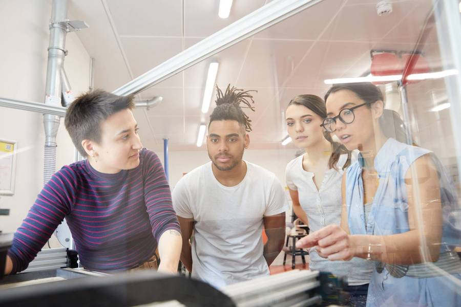 Product Foundry cohort members gathered around equipment in the Plus X Brighton Workshop