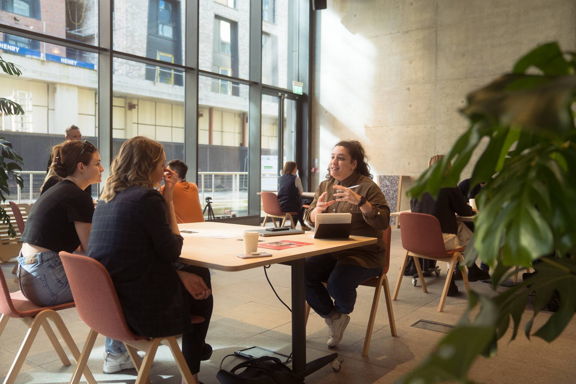 3 people chatting around a table 
