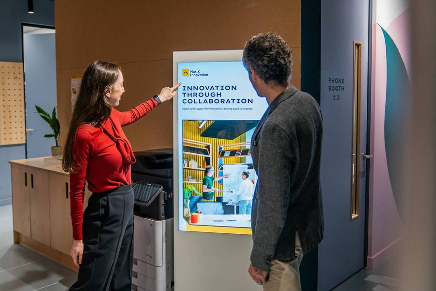 A team member showing a person around the Plus X Innovation Slough building.