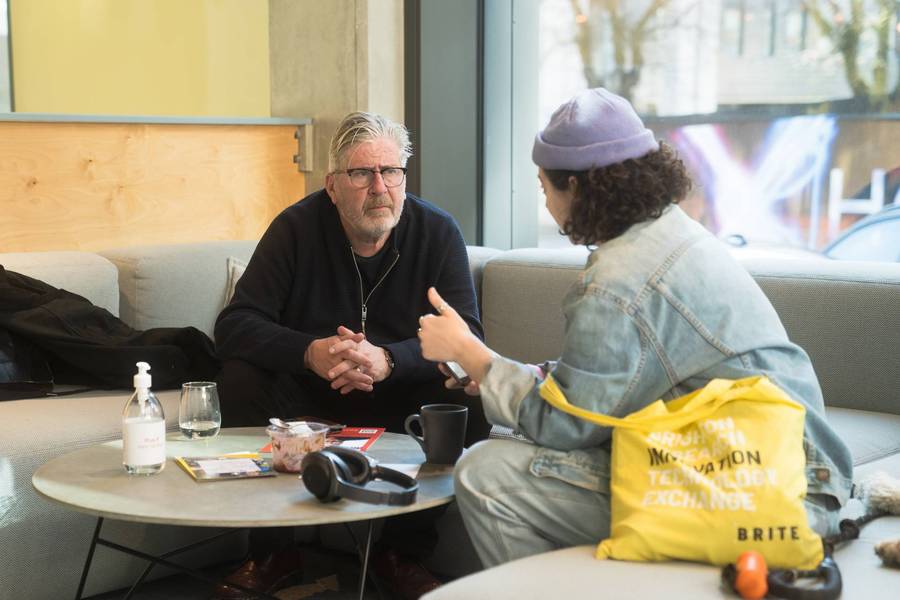 Two members talking in the Plus X Innovation Brighton events space.