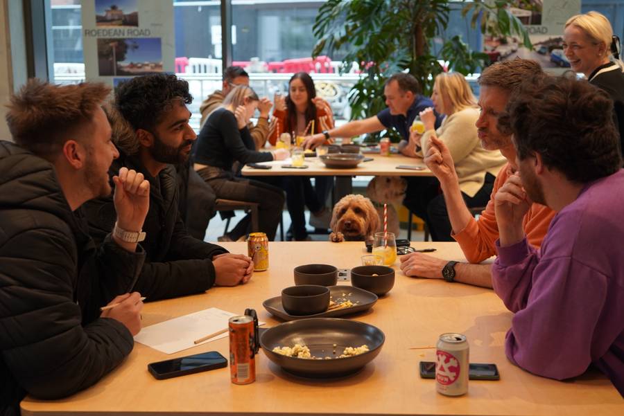 Members talking at a table during a Plus X Innovation event.