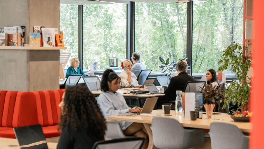 a couple of people sitting at a table with laptops