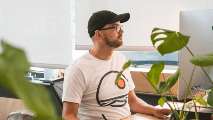A member working on a computer on their permanent resident desk at Plus X Innovation Brighton