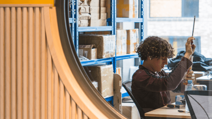 A person working in their private office space at Plus X Innovation Brighton with a banner saying 'most popular' on it