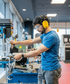 A person using tools in the workshop at Plus X Innovation Brighton