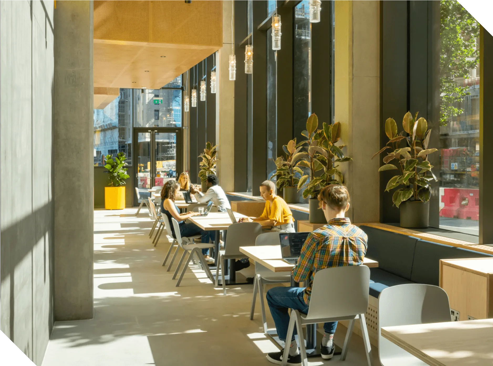People working in a sunny coworking space at Plus X Innovation Brighton