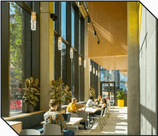 Coworkers sitting in the sunny cafe space of Plus X Innovation Brighton