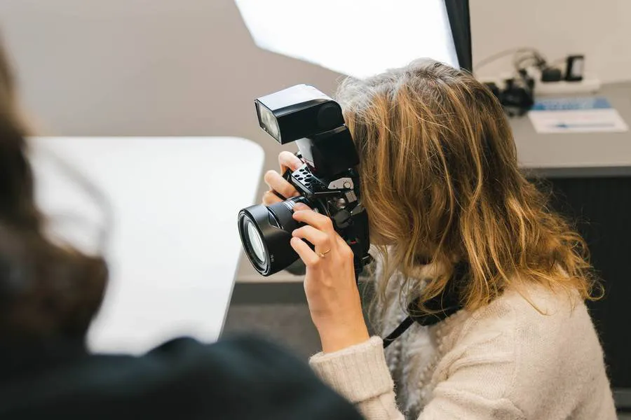 A person behind the camera during a photoshoot in the photography suite at Plus X Innovation Brighton
