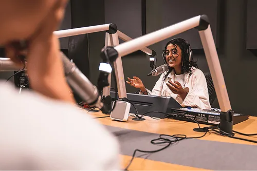 A person recording a podcast in the podcasting suite at Plus X Innovation Brighton