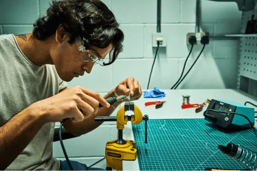 A person using tools in the workshop at Plus X Innovation Brighton