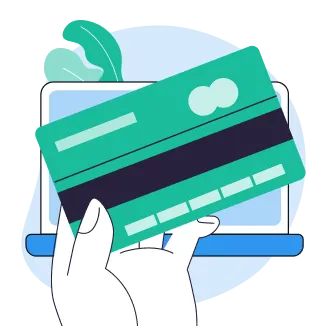 Hand holding a credit card in front of a laptop with green leaves in background.
