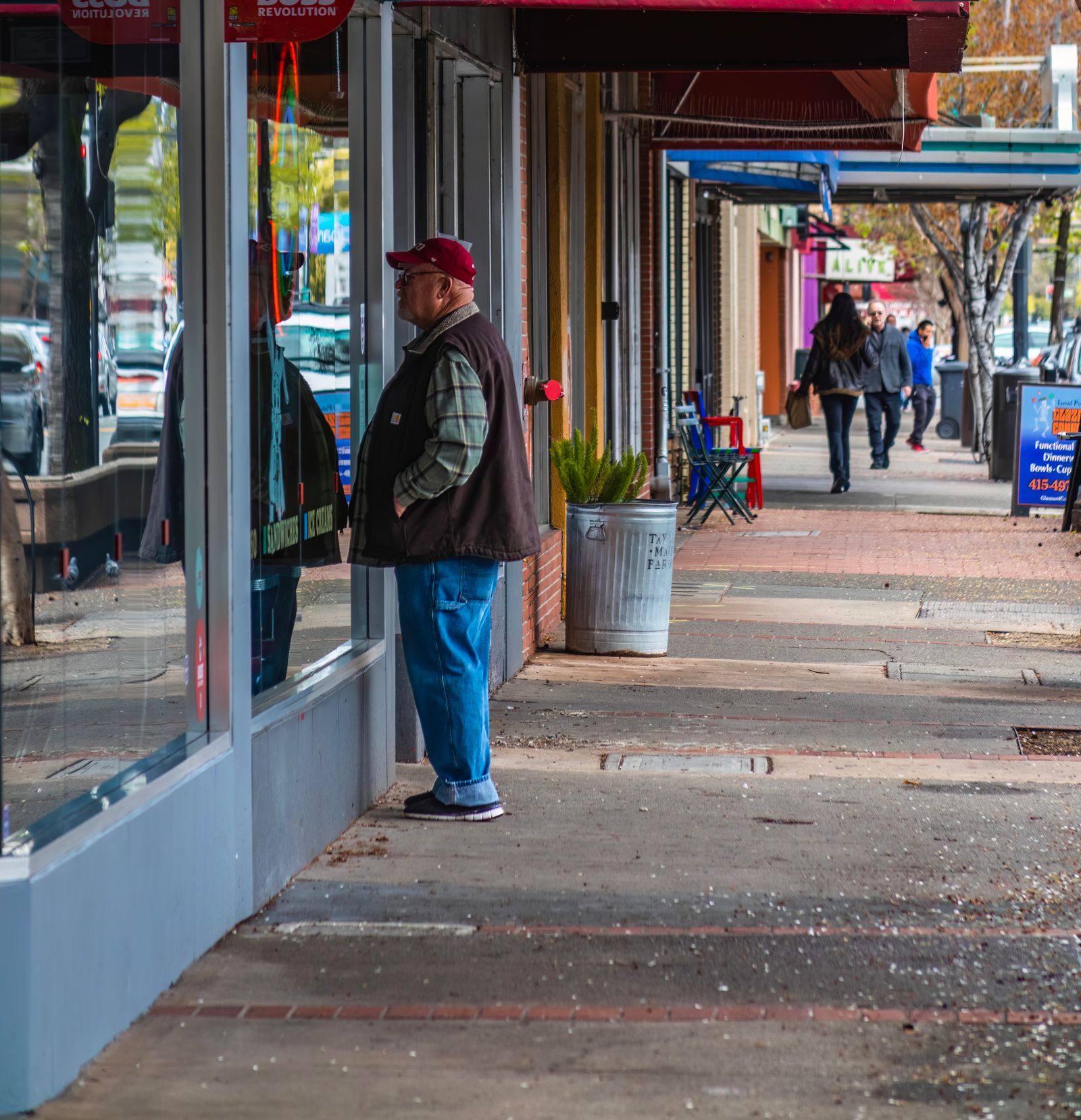 Sidewalk with uneven pavement in front of shopping center storefronts