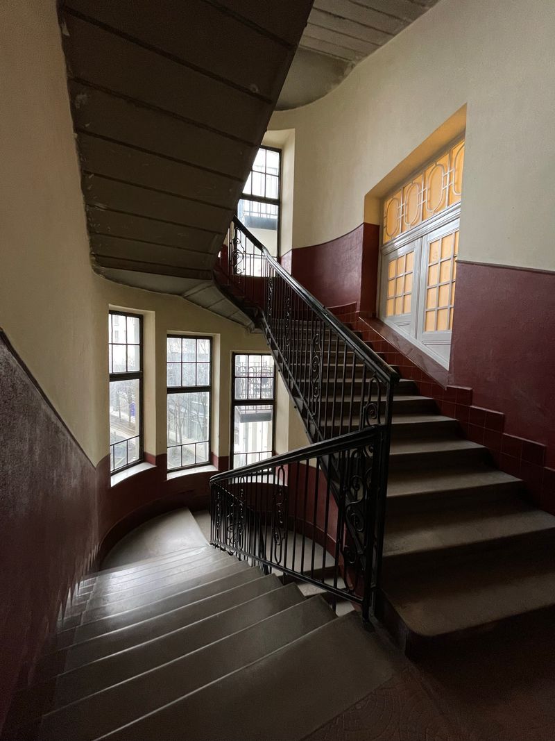 Interior staircase with metal handrail in an older building