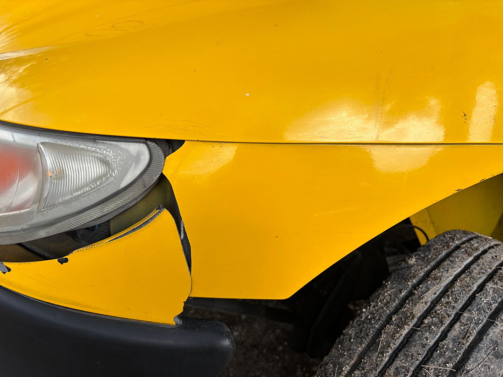 Front end collision damage on a passenger car fender and bumper