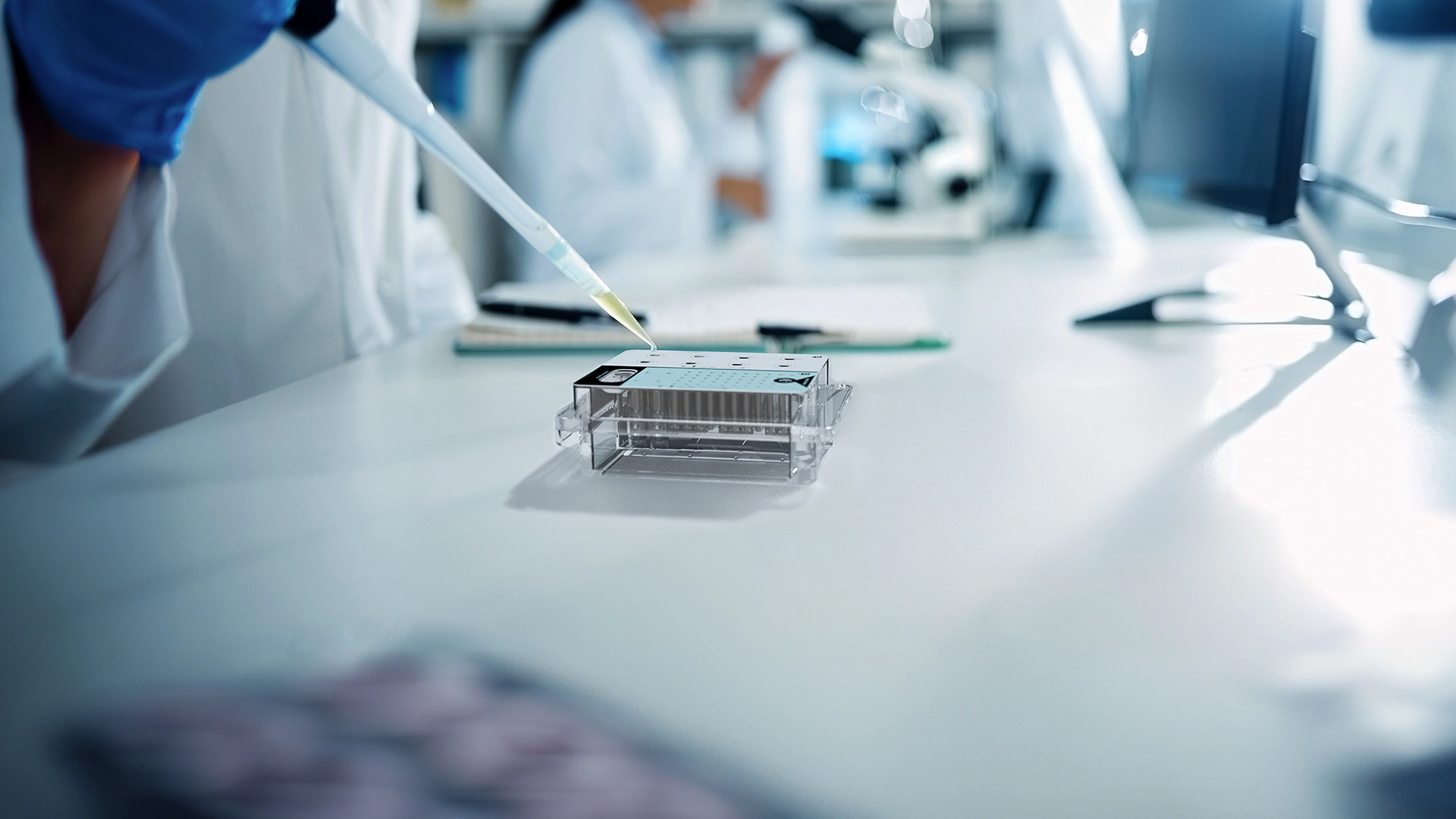 Lab technician using a pipette with a cartridge workflow for a protein analysis system.