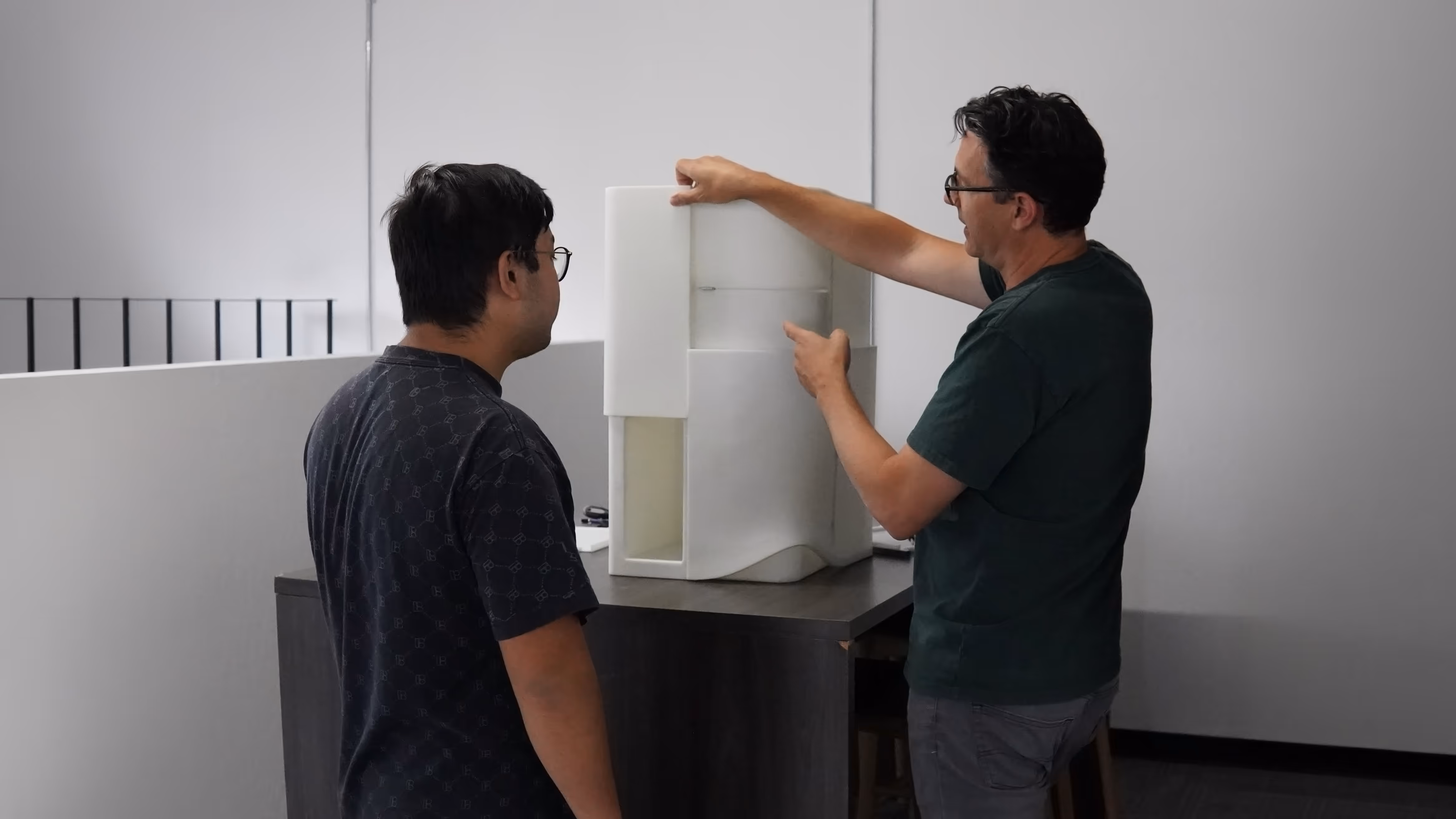 Speck Design team reviewing a physical prototype of the Encodia protein analysis instrument.