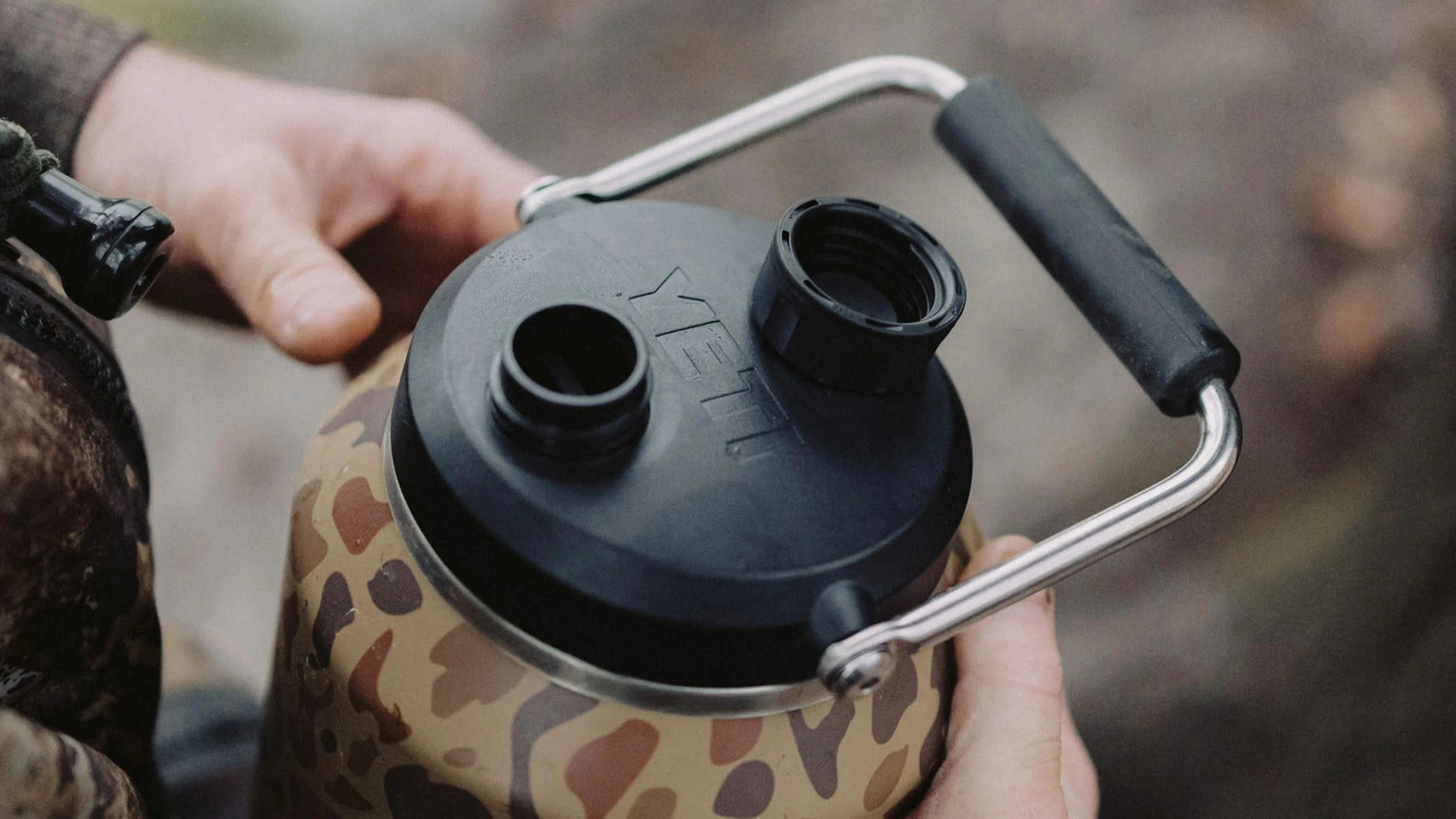 Pouring water from blue YETI Rambler Jug demonstrating improved pour performance and product design refinement