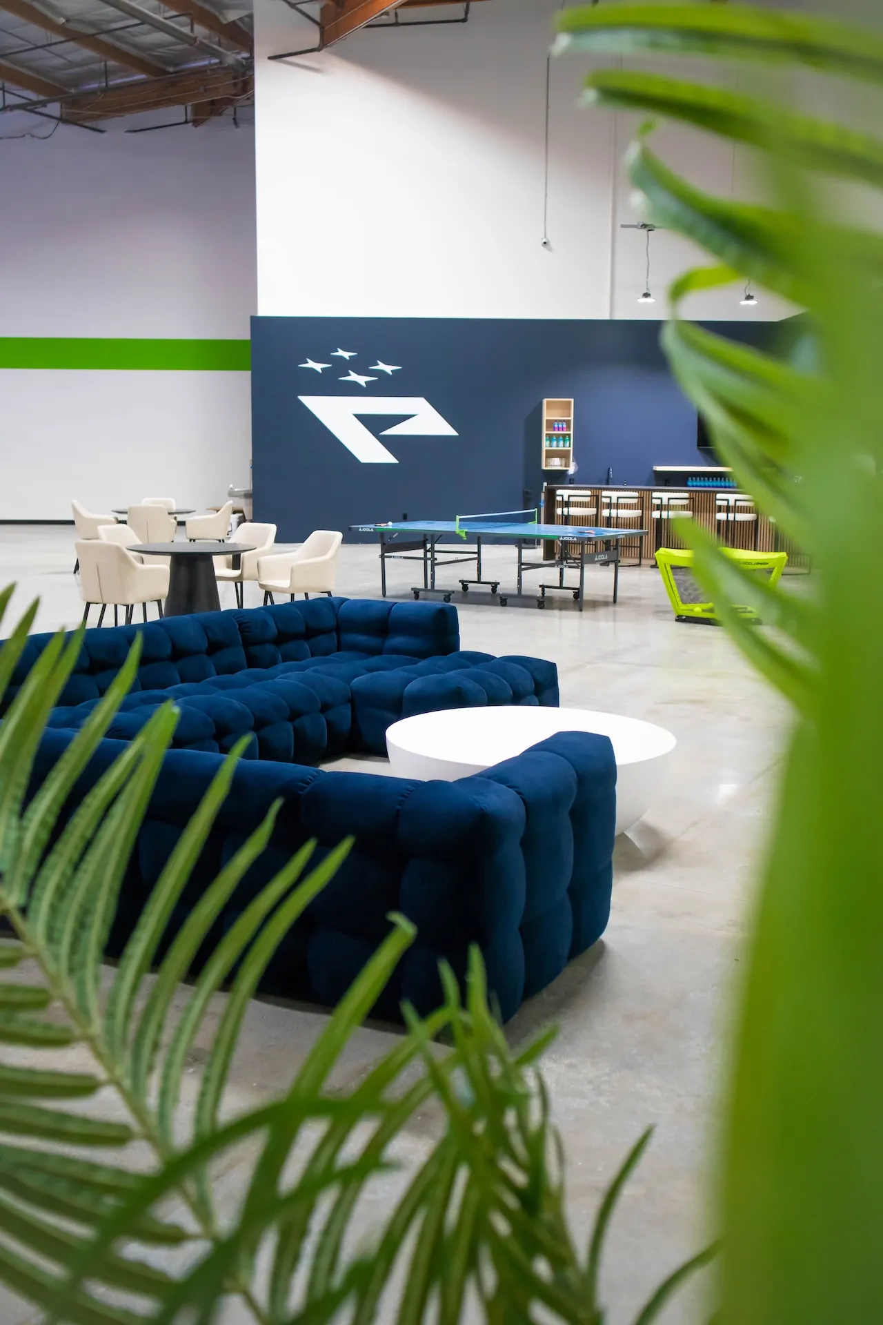 Lounge area with palm leaf fronds in foreground.