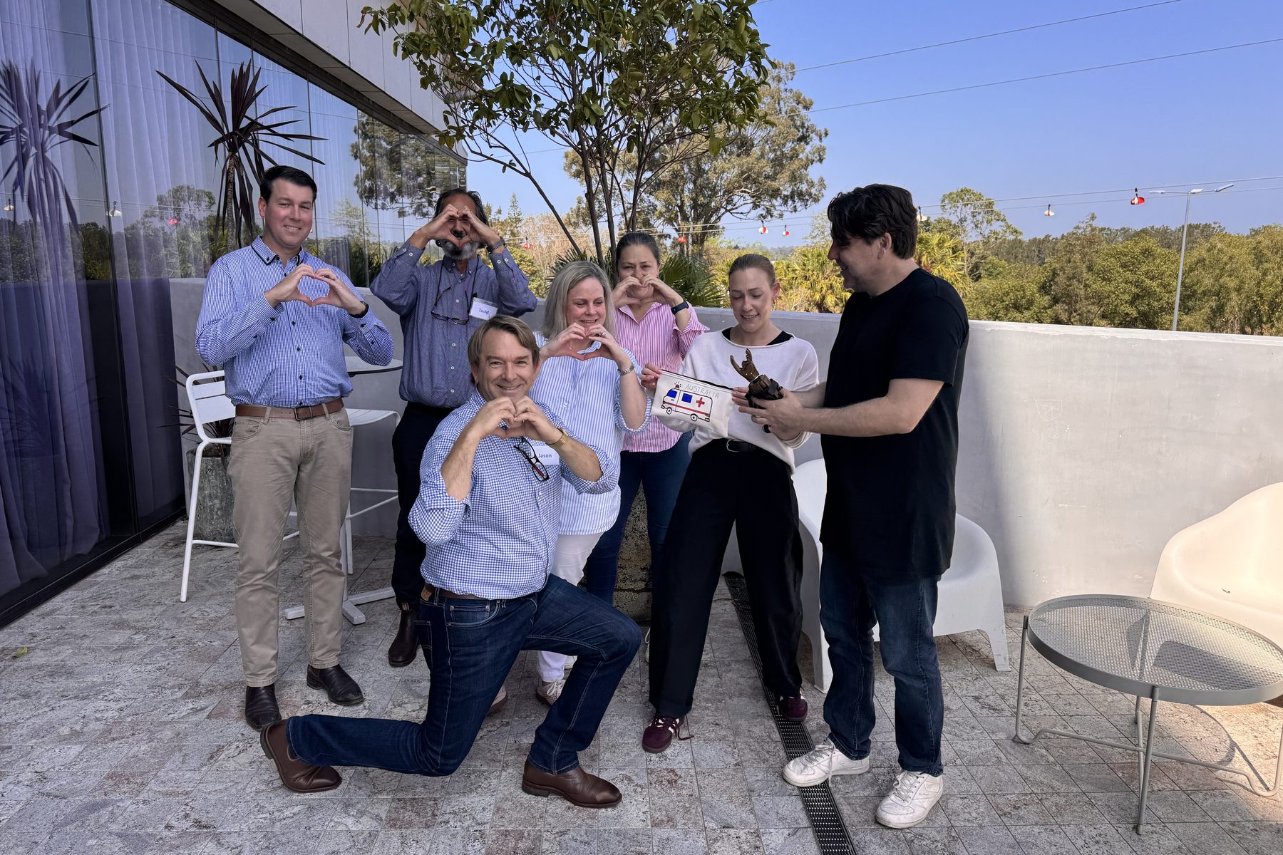 Queensland Ambulance Service leaders making heart shapes with their hands during the XEd Space workshop
