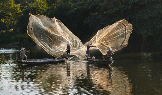 Versteckte Lagune per Boot & Velo in Hue: Hue: Fishermen throw a fishing net in the Morning