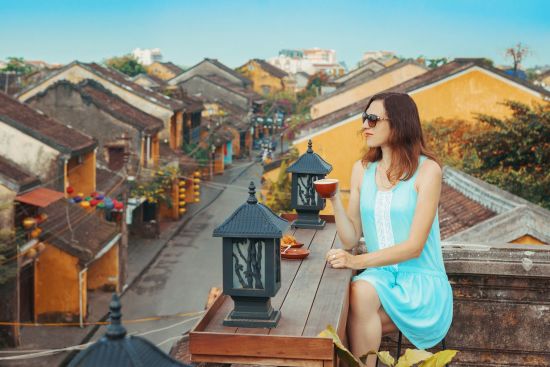 Le Vietnam pour les fins connaisseurs de Hanoi: Hoi An - Tourist having a coffee overlooking the old city