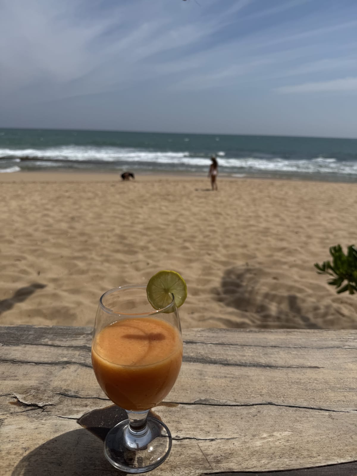 Getränk im Vordergrund und im Hintergrund der Strand