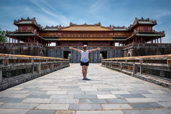 Zentralvietnam aktiv erleben ab Hue: Young woman at the gates of the imperial city of Hue