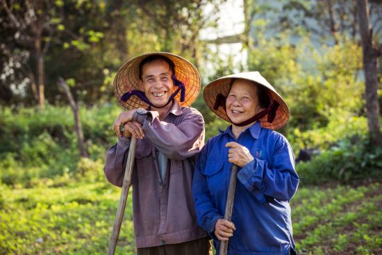 Zentralvietnam aktiv erleben ab Hue: Smiling old farmer couple with conical hats (non la)