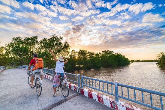Faszinierendes Mekong Delta - ab Saigon bis Phnom Penh: Mekong Delta: Tourist couple riding bicycle