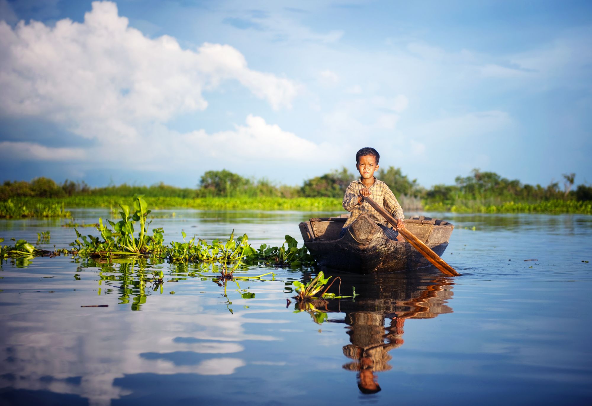 Croisière fluviale vers Saigon de Siem Reap: Tonle Sap boy travelling by boat to his floating village