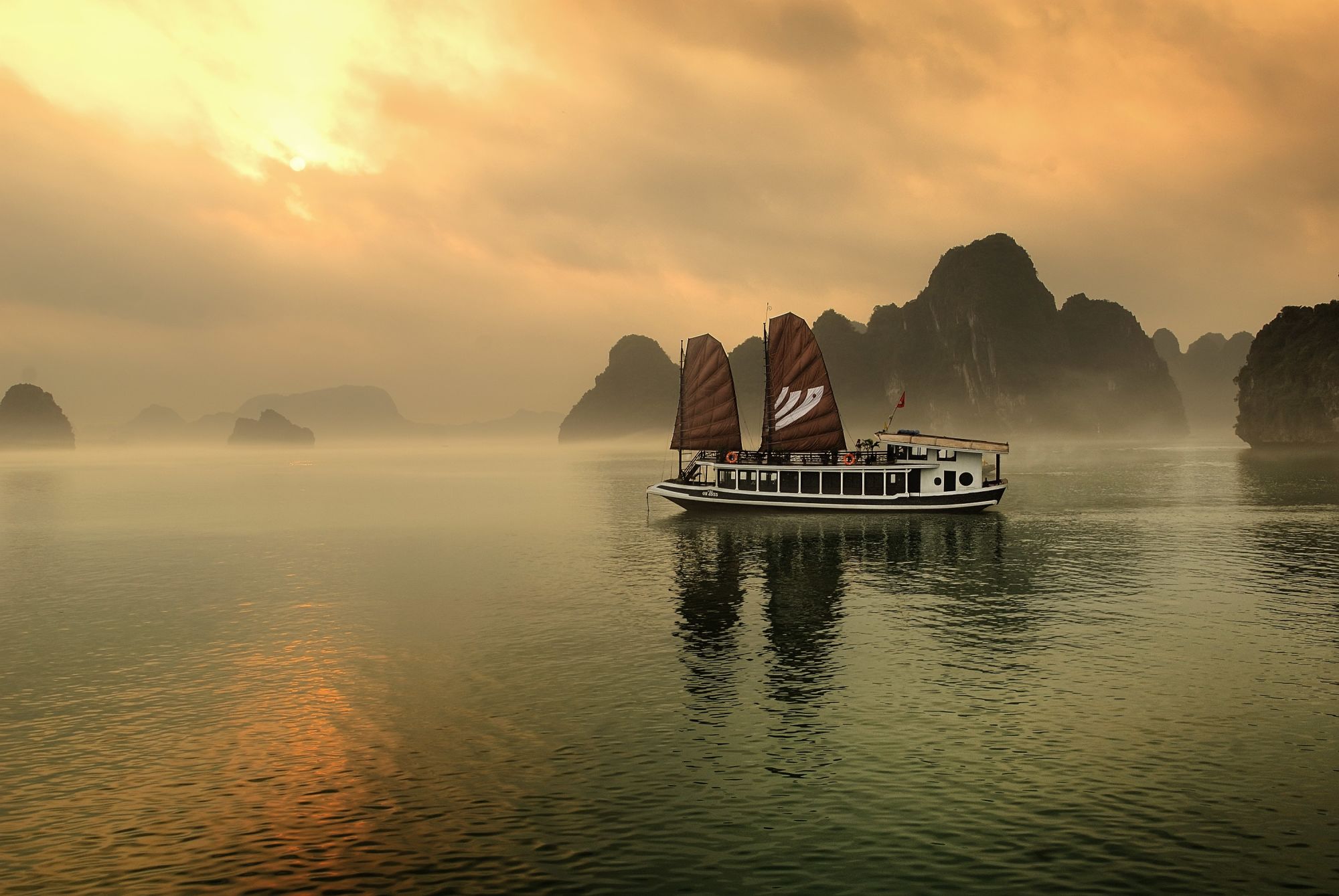 Croisières dans la baie de Halong avec le bâteau privé «Legend Halong» de Hanoi: exterior: beach: exterior: Bhaya Legend while sunset