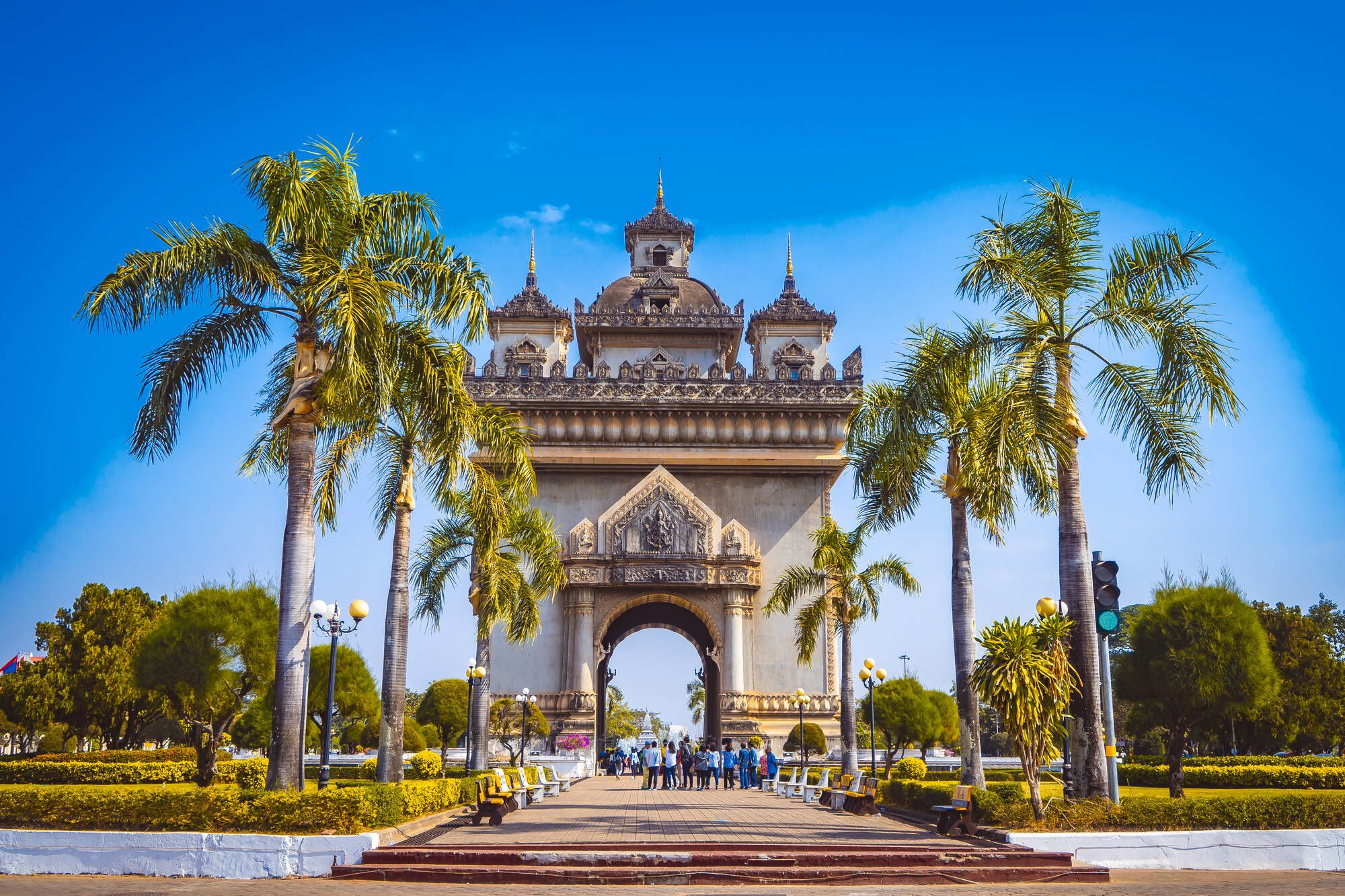 Découverte intense du Laos de Vientiane: Patuxay monument with palm trees