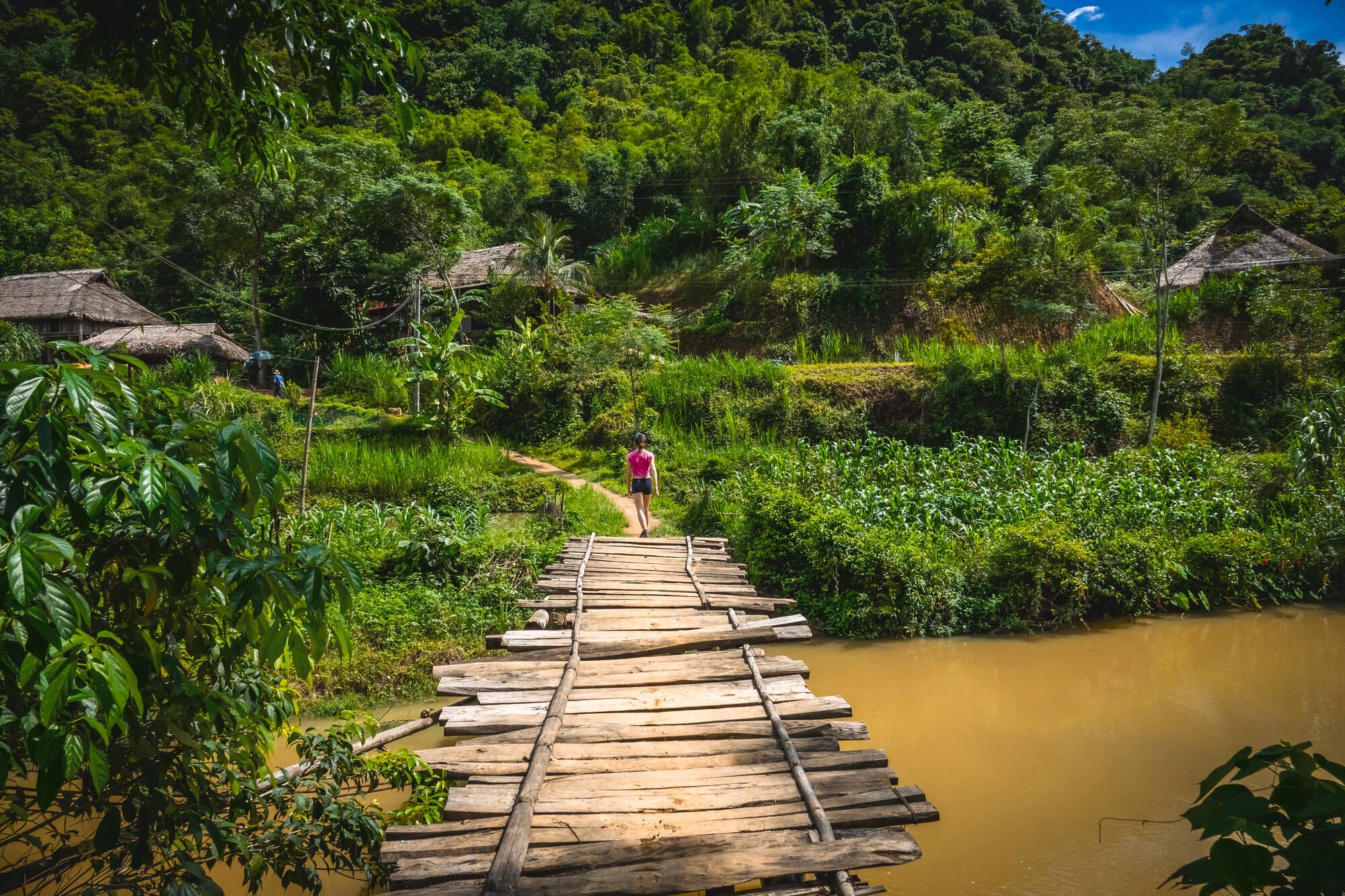 Impressionen Nordvietnams ab Hanoi: Young woman hiking on a wooden bridge in Pu Luong