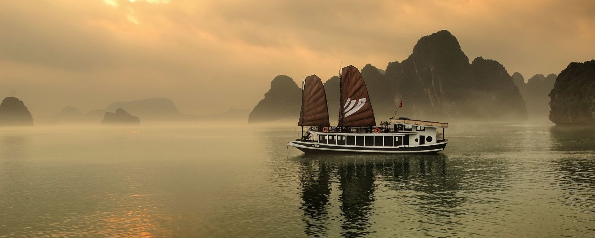 Croisières dans la baie de Halong avec le bâteau privé «Legend Halong» 3D de Hanoi: exterior: beach: exterior: Bhaya Legend while sunset