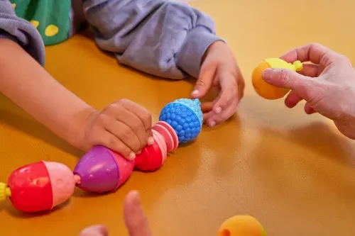 a child playing with a chain of connected balls at the physiokiez lab in berlin