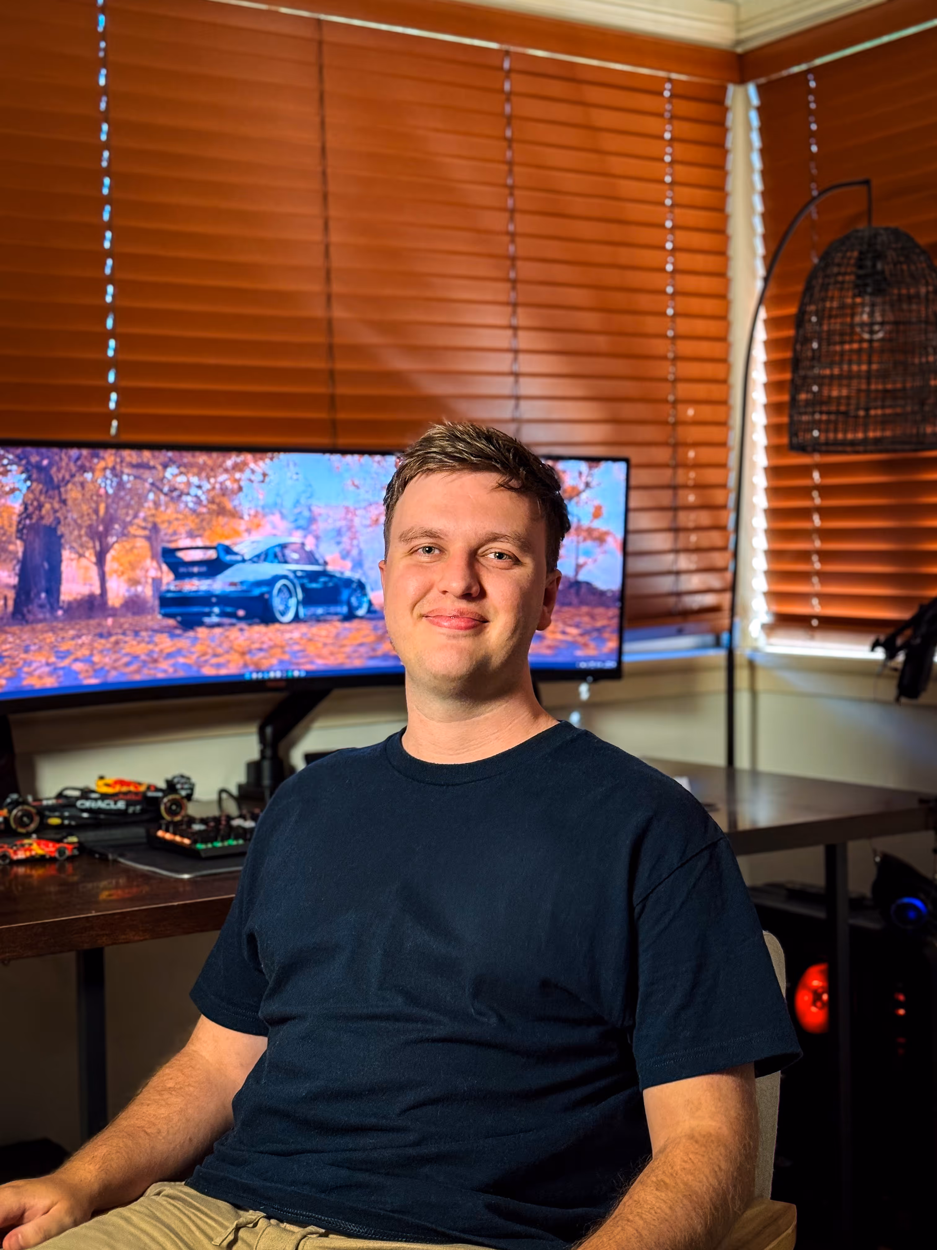 A headshot of graphic designer and business owner Ryan Harris seated in his design studio.