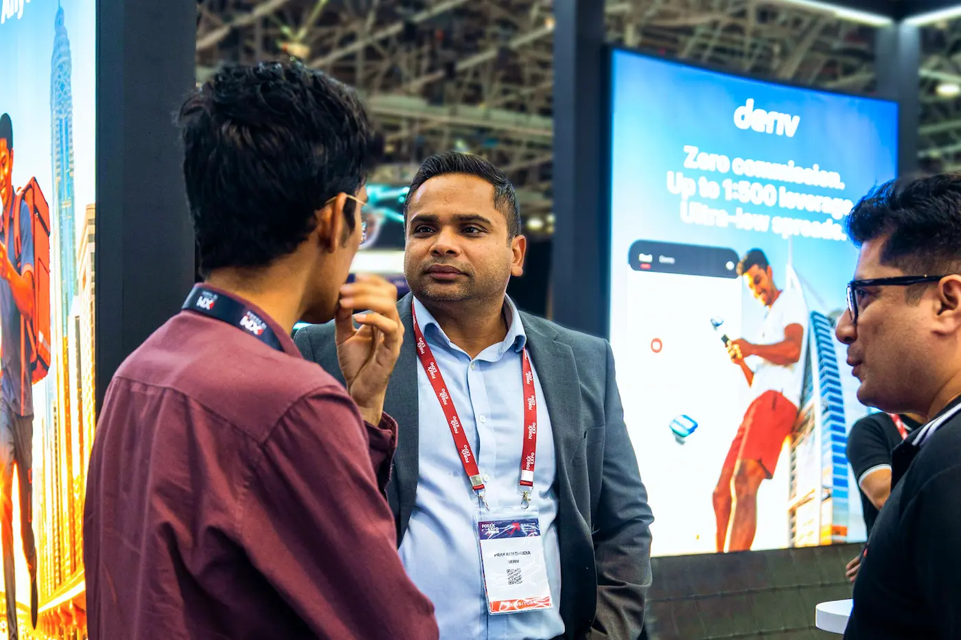 Team members networking at a Deriv event, discussing tools that power trading for millions worldwide.