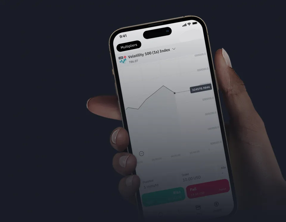 A hand holding phone displaying Deriv Trader app with Volatility 100 (1s) Index chart