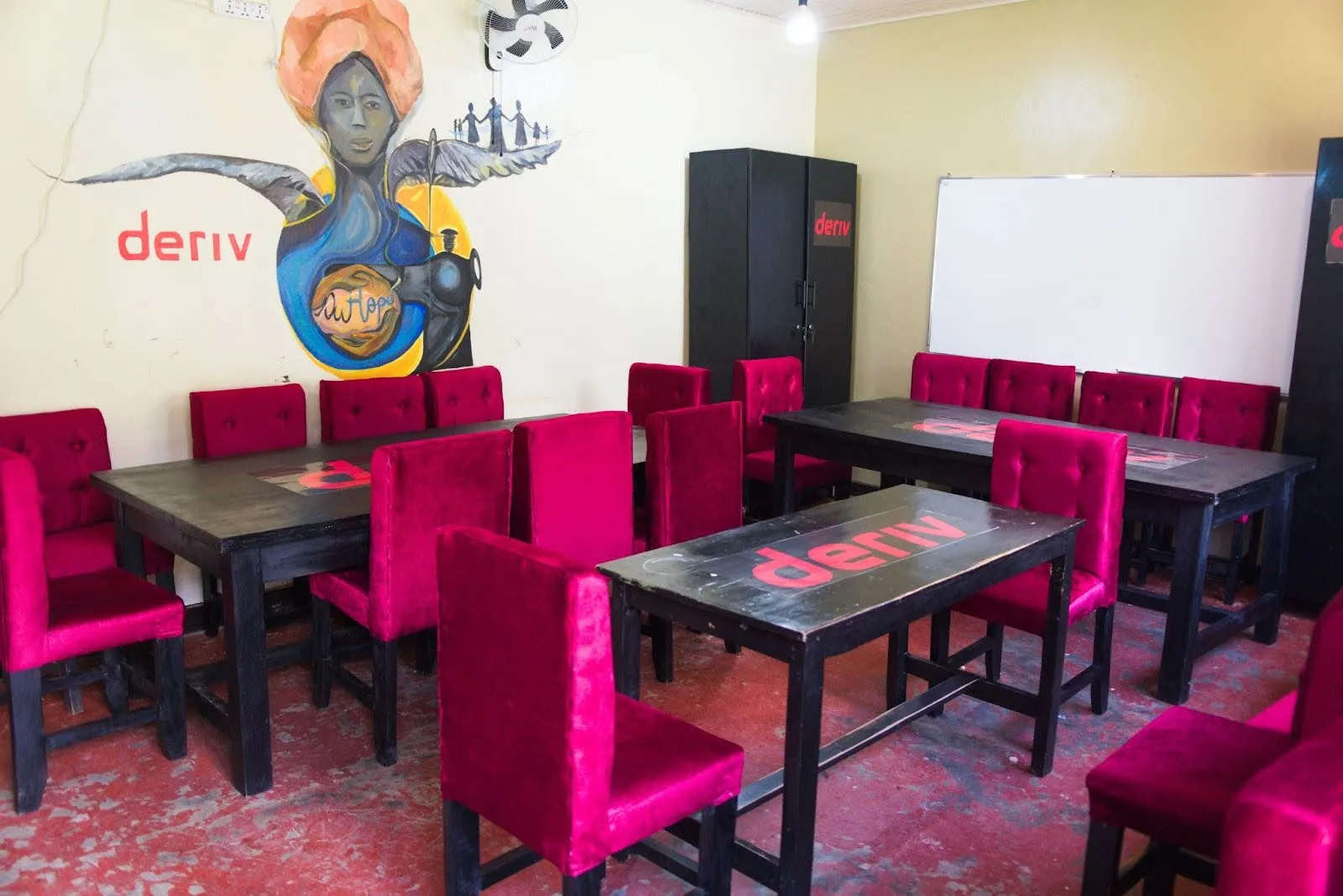 Tables and cupboards with Deriv logo