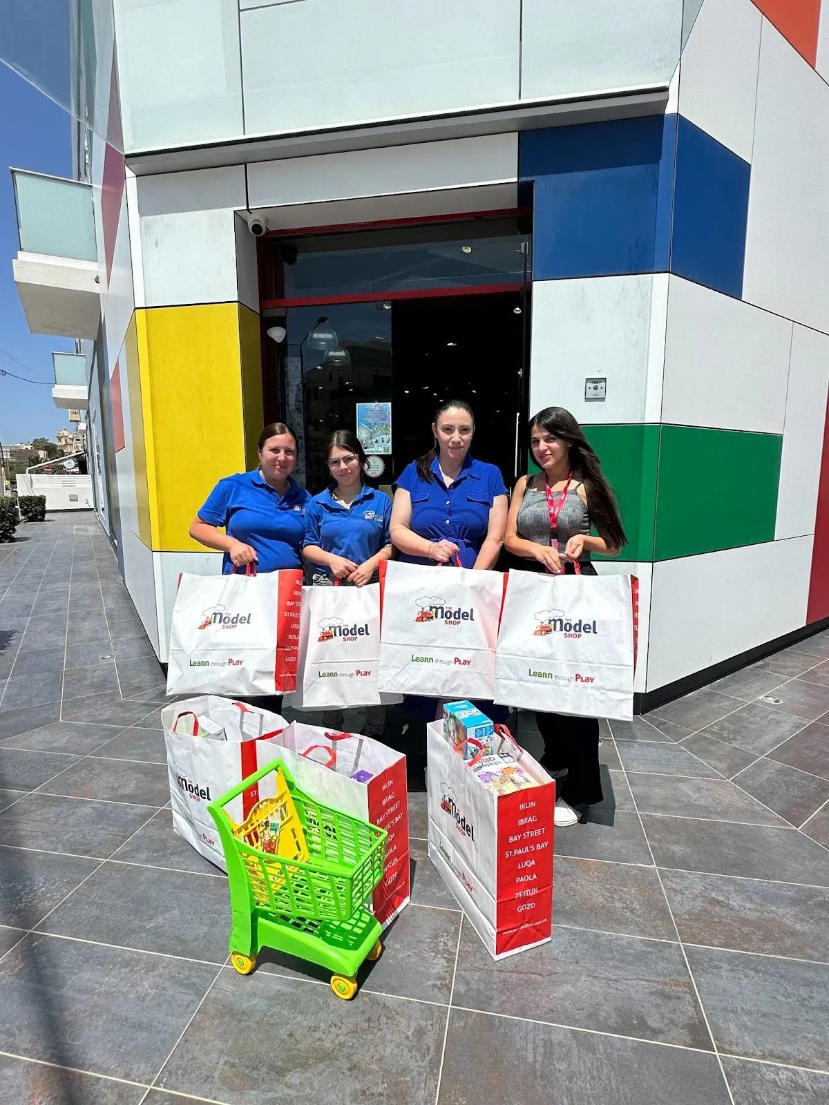 Two Deriv employees and toy store representatives with toys purchased for Puttinu Cares children.
