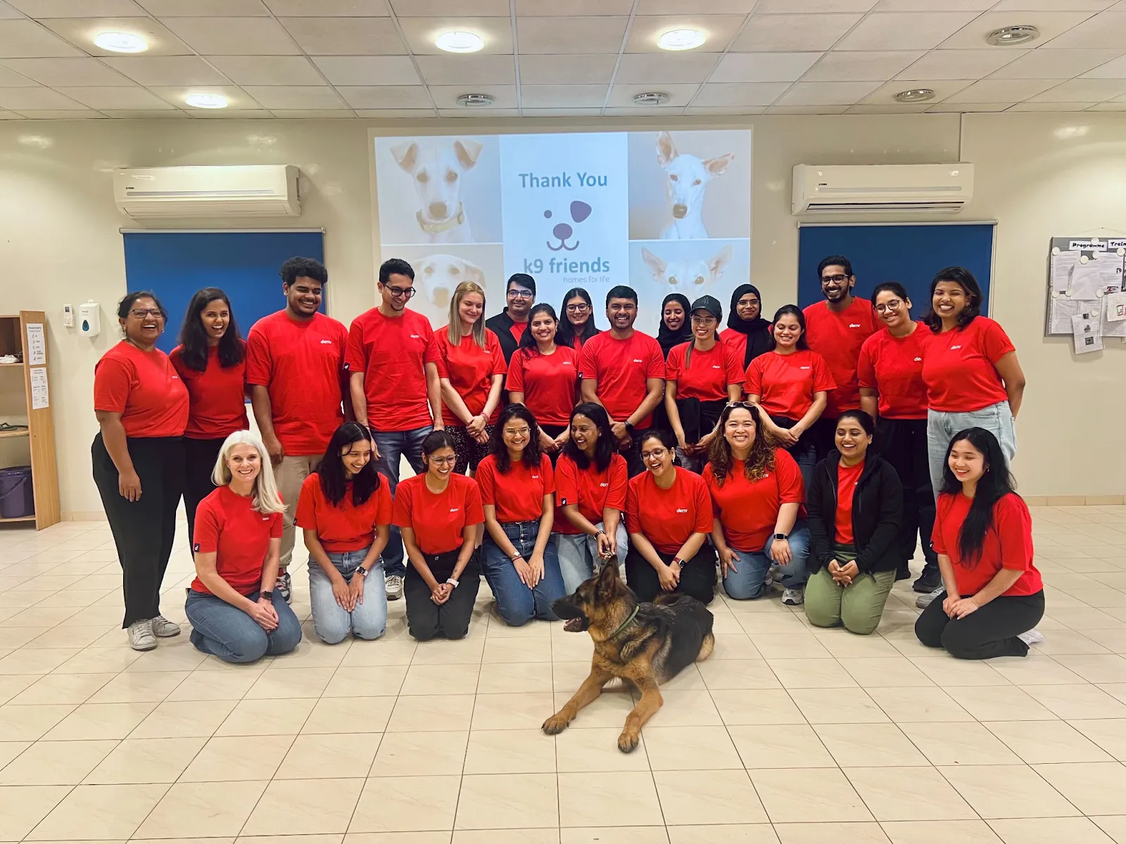 Deriv employees with a dog at K9 Friends NGO, showing their support and participation in the animal shelter initiative.