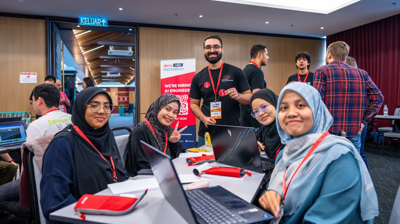 Participants interacting with tech experts and collaborating on AI projects at Deriv's second AI Hackathon.