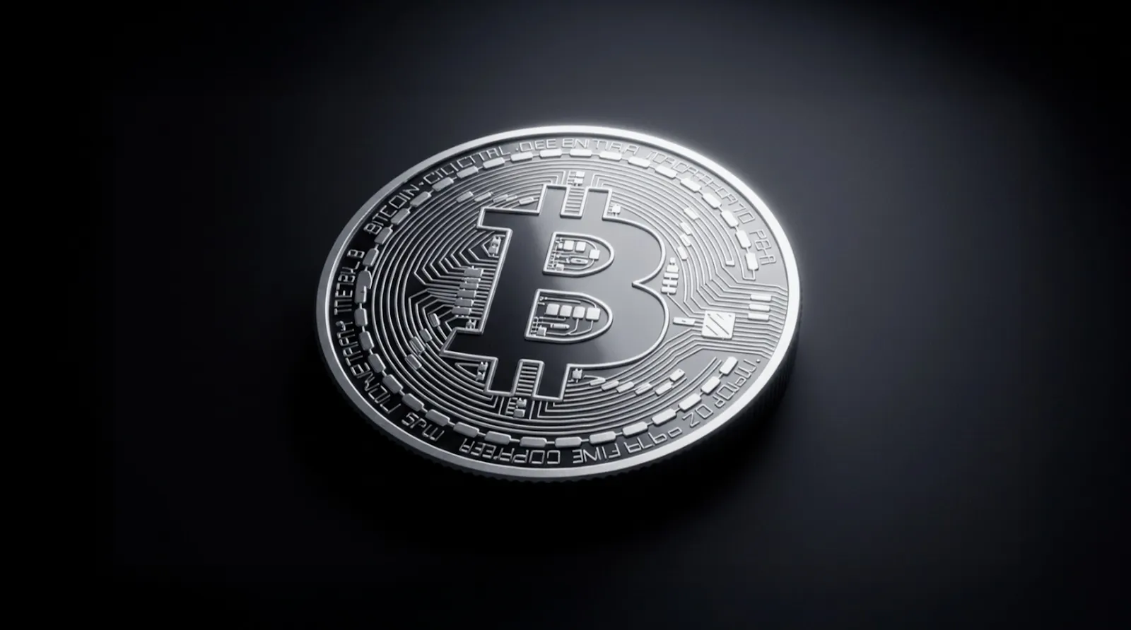 High-resolution image of a metallic Bitcoin coin placed on a dark surface with a spotlight glow effect.